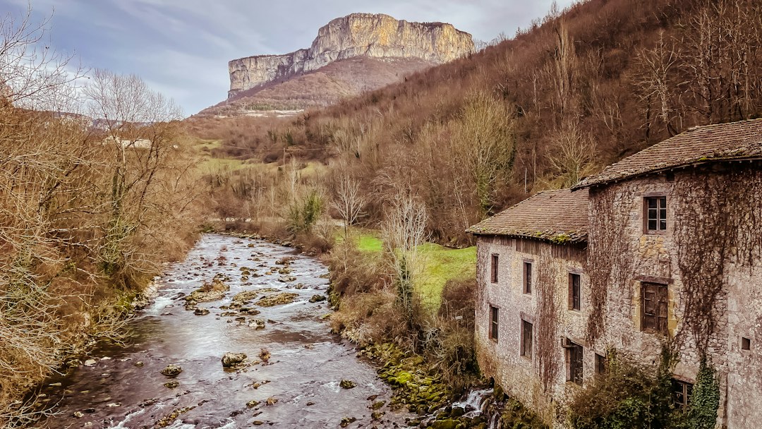 Rivière et bâtisse en pierre au pied des montagnes
