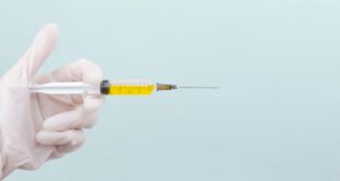 Seringue tenue par une main gantée : vaccination grippe 2026