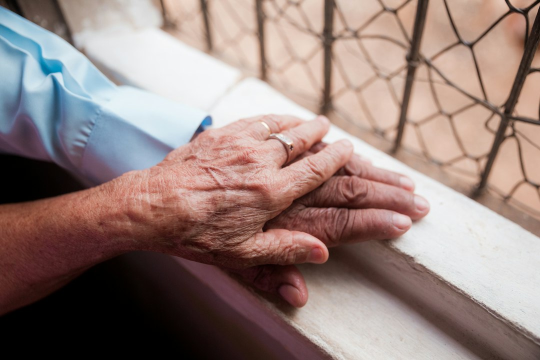 Une personne âgée tient la main d'un proche plus jeune