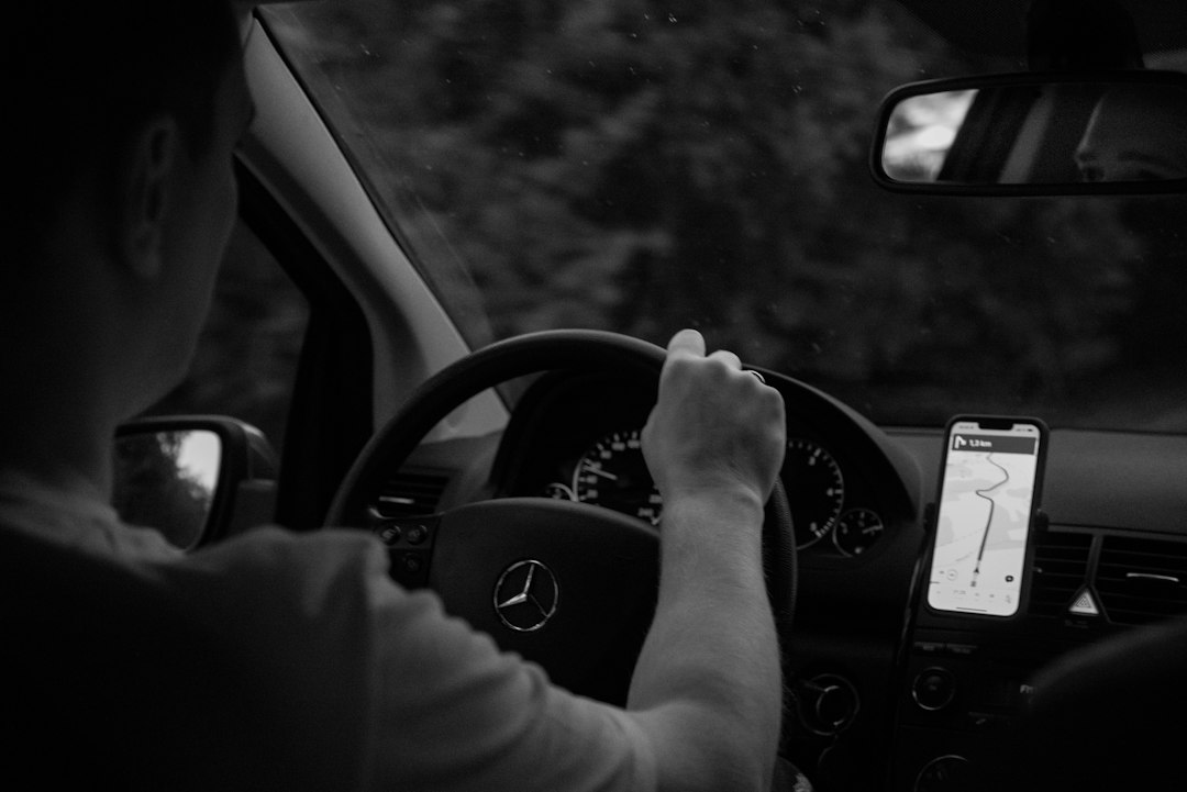 Mains sur le volant et smartphone posé sur un support, sans le tenir en main